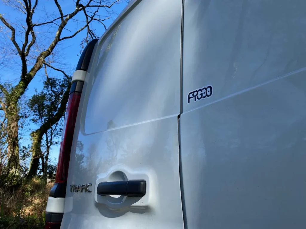 Gros plan du logo FYGOO sur la porte arrière du véhicule de l’atelier à Capbreton, spécialisé en réparation et finition de planches de surf